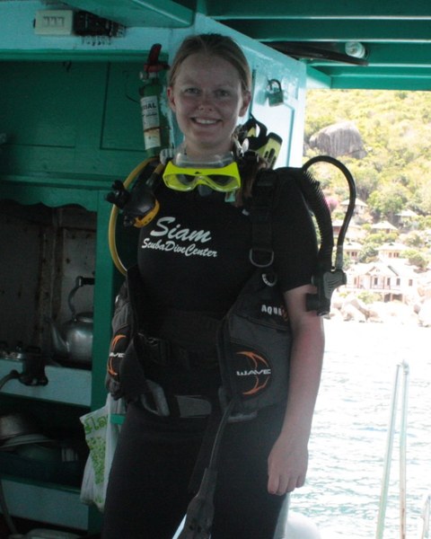 A real photo: me on the dive boat in a wetsuit and gear, smiling, before the dive.